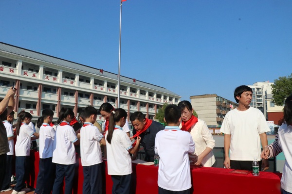 1791798019415344.jpg 为校领导戴红领巾.JPG